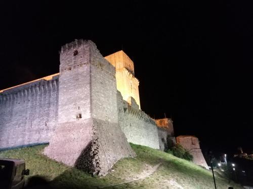 un gran castillo iluminado por la noche en B&B La Giara di Assisi, en Asís