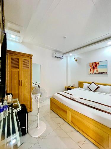 a bedroom with a large bed and a desk at Diamond Hotel in Vung Tau