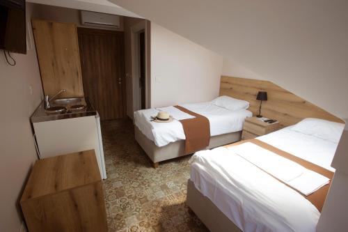 a hotel room with two beds and a sink at Soul River e cucina in Pančevo