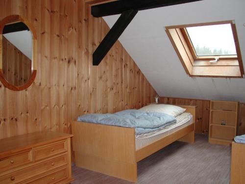 ein kleines Schlafzimmer mit einem Bett und einem Fenster in der Unterkunft Zigeunermühle in Weißenstadt