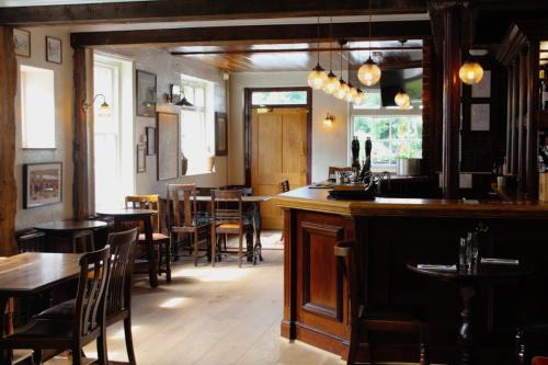 a bar in a restaurant with tables and chairs at The George Inn St Mary Bourne in Saint Mary Bourne