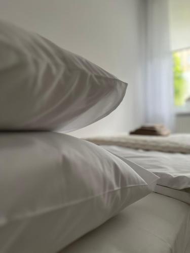 a white bed with two pillows on top of it at Apartament Pod Kamienną Górą II in Gdynia