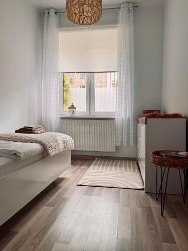a bedroom with a bed and a window and a rug at Apartament Pod Kamienną Górą II in Gdynia