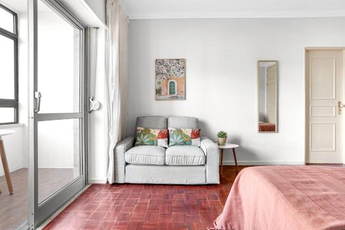 sala de estar con sofá y ventana en Wonderful Shared Apartment in Alfornelos - NEAR METRO! en Lisboa