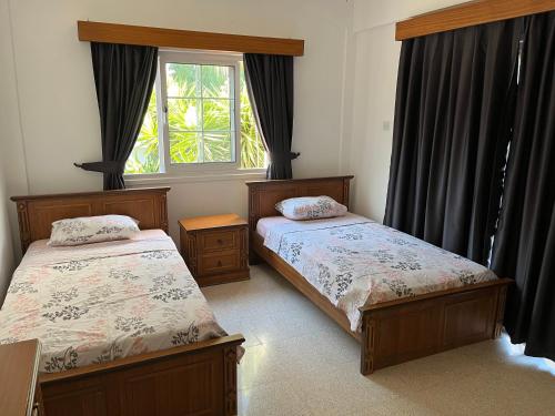 a bedroom with two beds and a window at Palm Villa in Kyrenia