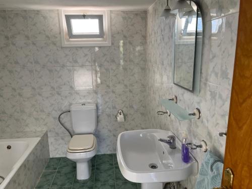 a bathroom with a white toilet and a sink at Palm Villa in Kyrenia