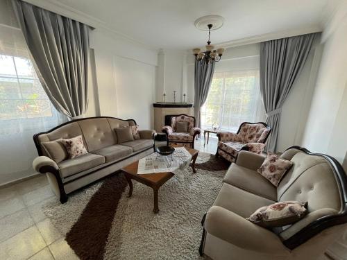 a living room with two couches and a coffee table at Palm Villa in Kérynia