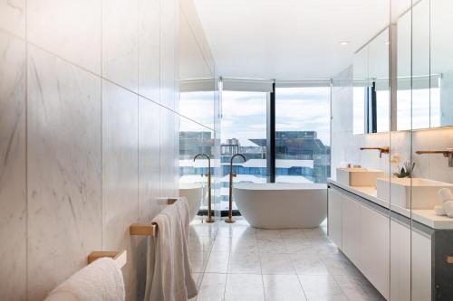 een badkamer met een bad en een groot raam bij Luxurious 3 Bed Fortitude Valley Penthouse Retreat in Brisbane