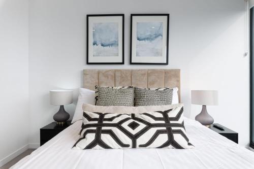 een slaapkamer met een bed met drie foto's aan de muur bij Luxurious 3 Bed Fortitude Valley Penthouse Retreat in Brisbane
