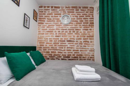 a bedroom with a brick wall and a bed with two towels at Апартаменти MYFREEDOM поруч із метро Тараса Шевченка in Kyiv