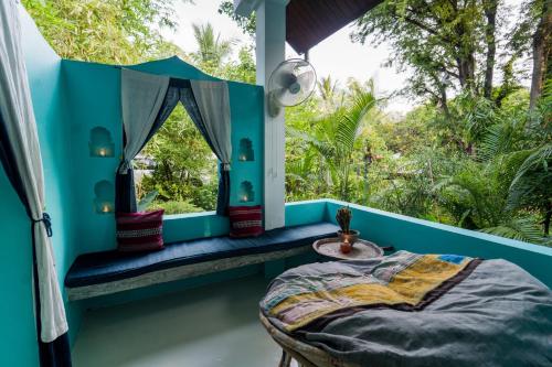 a room with a bed and a window and trees at Ock Pop Tok Mekong Villa in Luang Prabang