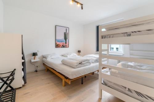 een slaapkamer met 2 stapelbedden en een ladder bij Maison les Bruyères in Blankenberge