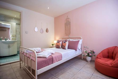 アギオス・ニコラオスにあるLake Spirit Apartmentのベッドルーム(白いベッド1台、赤い椅子付)