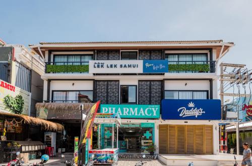 a building with a sign on the side of it at Lek Lek Samui Room X Coffee Bar in Chaweng