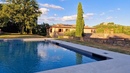 a swimming pool in front of a house at La Corte del Chianti Classico in Gaiole in Chianti