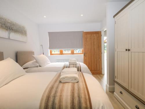 two beds in a bedroom with white walls at Lapwings in Fareham