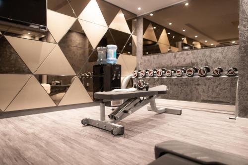 a room with a bench in a gym with bottles of water at PLAZA Premium Heidelberg in Heidelberg
