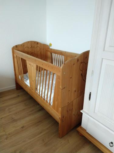 a wooden crib in a room next to a door at Wohnung-Aublick in Butzbach