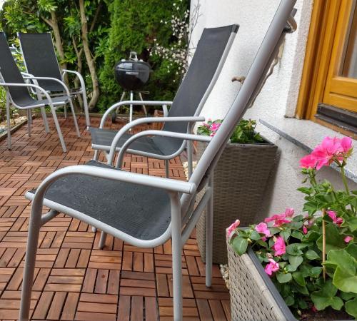 a row of chairs sitting on a patio with flowers at Wohnung-Aublick in Butzbach