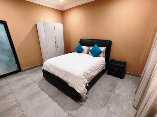 a bedroom with a large bed with blue pillows at Parys In town Guest lodge and Conference Center in Parys