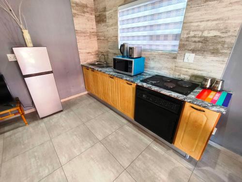 a small kitchen with a stove and a refrigerator at Parys In town Guest lodge and Conference Center in Parys