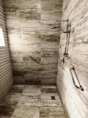 a bathroom with a shower with a stone wall at Parys In town Guest lodge and Conference Center in Parys