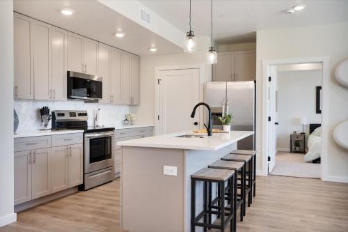 eine Küche mit weißen Schränken und eine Kücheninsel mit Hockern in der Unterkunft Family Friendly Lagoon Get Away condo in Atkinville