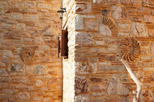 a brick wall with a window on a building at Peroulia Stone Villa Koroni - Grèce, Péloponnèse in Koroni
