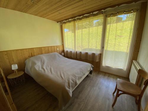une chambre avec un lit, une fenêtre et une chaise dans l'établissement Charmant appart 4 pers. avec chambre indép., terrasse, Wi-Fi, parking, skis, proche Crest-Voland - FR-1-733-110, à Crest-Voland