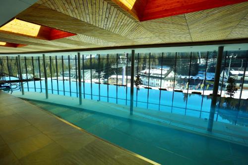 a swimming pool with a view of a building at Hotel SOREA SNP in Demanovska Dolina