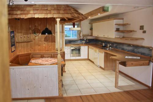a large kitchen with wooden cabinets and a table at Ferienwohnung Handweberei Huber in Saaldorf-Surheim