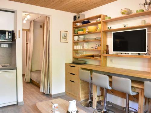 - un salon avec un comptoir, une télévision et des chaises dans l'établissement Studio cosy avec piscine, au pied des pistes - Méribel - FR-1-180-593, à Les Allues