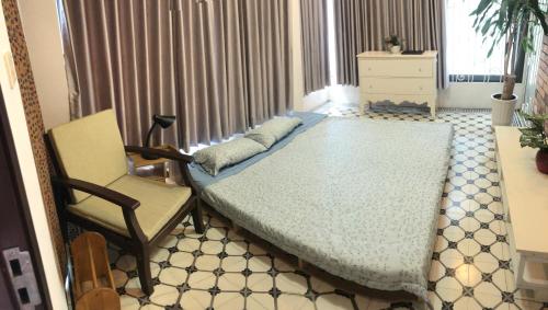 ein Schlafzimmer mit einem Bett, einem Stuhl und einem Fenster in der Unterkunft Mika Homestay Friends House in Hanoi