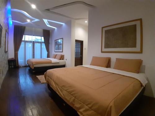 a hotel room with two beds and a couch at De Summit Villa & View in Puncak