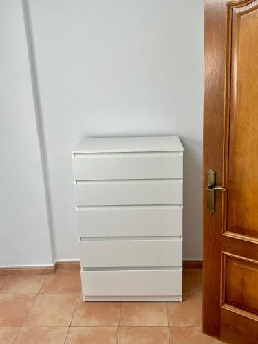 a white dresser in a room next to a door at Acogedora casita en Mugardos. in Mugardos