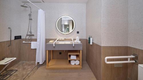 a bathroom with a sink and a mirror at Hilton Garden Inn Liaocheng Jiangbei Shuicheng in Liaocheng