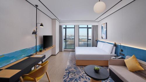 Habitación de hotel con cama y sofá en Hilton Garden Inn Liaocheng Jiangbei Shuicheng, en Liaocheng