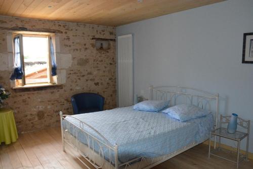 a bedroom with a white bed and a window at le Moulin de Garreau in Saint-Martin-des-Fontaines