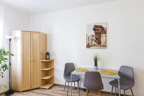 een eetkamer met een tafel en stoelen en een kast bij Apartament 2 pokojowy Gdańsk in Gdańsk