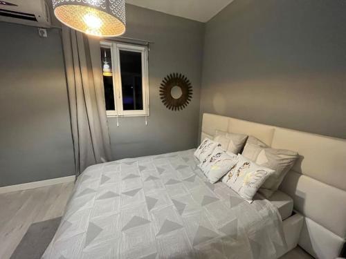 a bedroom with a white bed with pillows and a mirror at Destination Confidentielle in Clermont-Ferrand
