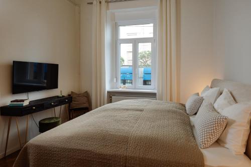 a bedroom with a bed and a tv and a window at Smaragd Residence Zagreb Downtown in Zagreb
