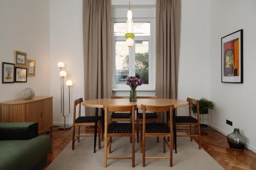 a living room with a table and chairs at Smaragd Residence Zagreb Downtown in Zagreb