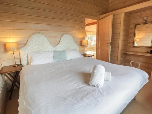 a bedroom with a white bed with two towels on it at Lapwing Lodge in Dumfries