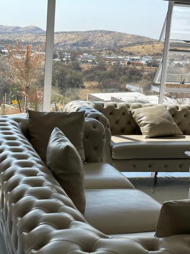 a large couch in a room with a large window at Avis sunrise view in Windhoek