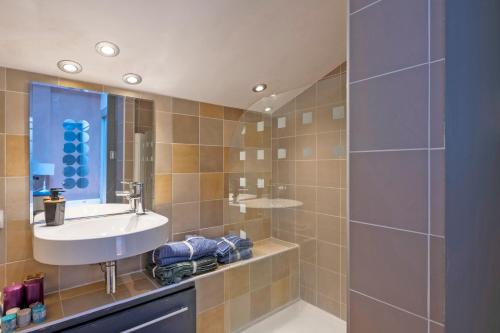 La salle de bains est pourvue d'un lavabo et d'une douche. dans l'établissement Le Scarlett - Maison à 300m de la plage, à Palavas-les-Flots