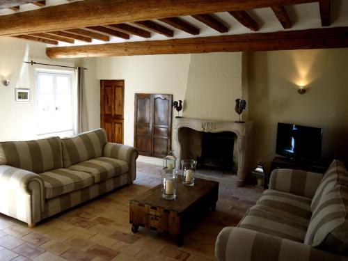 a living room with two couches and a fireplace at La Bergerie Provencale - Luberon - Provence - villa with heated pool in Roussillon
