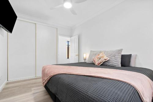 a bedroom with a large bed in a white room at The Shamrock House A in Renmark