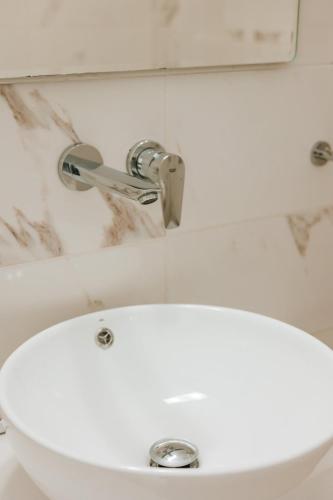 a white sink with a faucet on top of it at Finikas Home in Kamari
