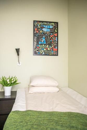 a bed in a room with a picture on the wall at Hotel Kupolen in Borlänge