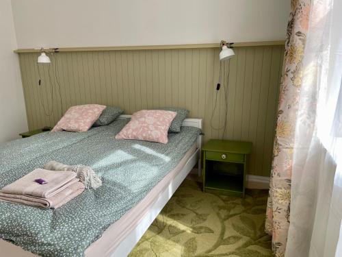 Un dormitorio con una cama con almohadas rosas. en Munga 4 Wiljandi, en Viljandi